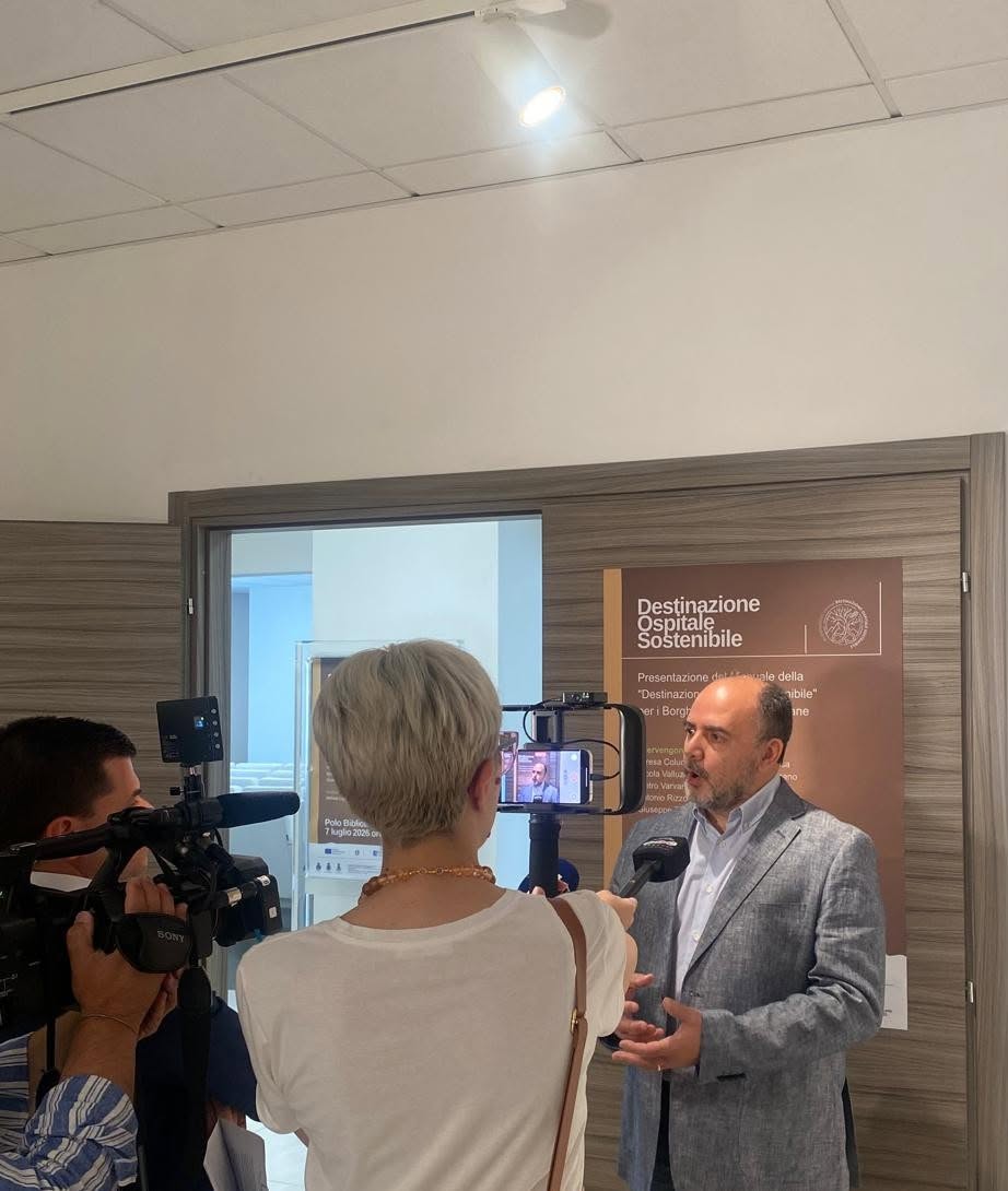 Television interview on the sidelines of the press conference, beside the &ldquo;Sustainable Hospitality Destination&rdquo; banner