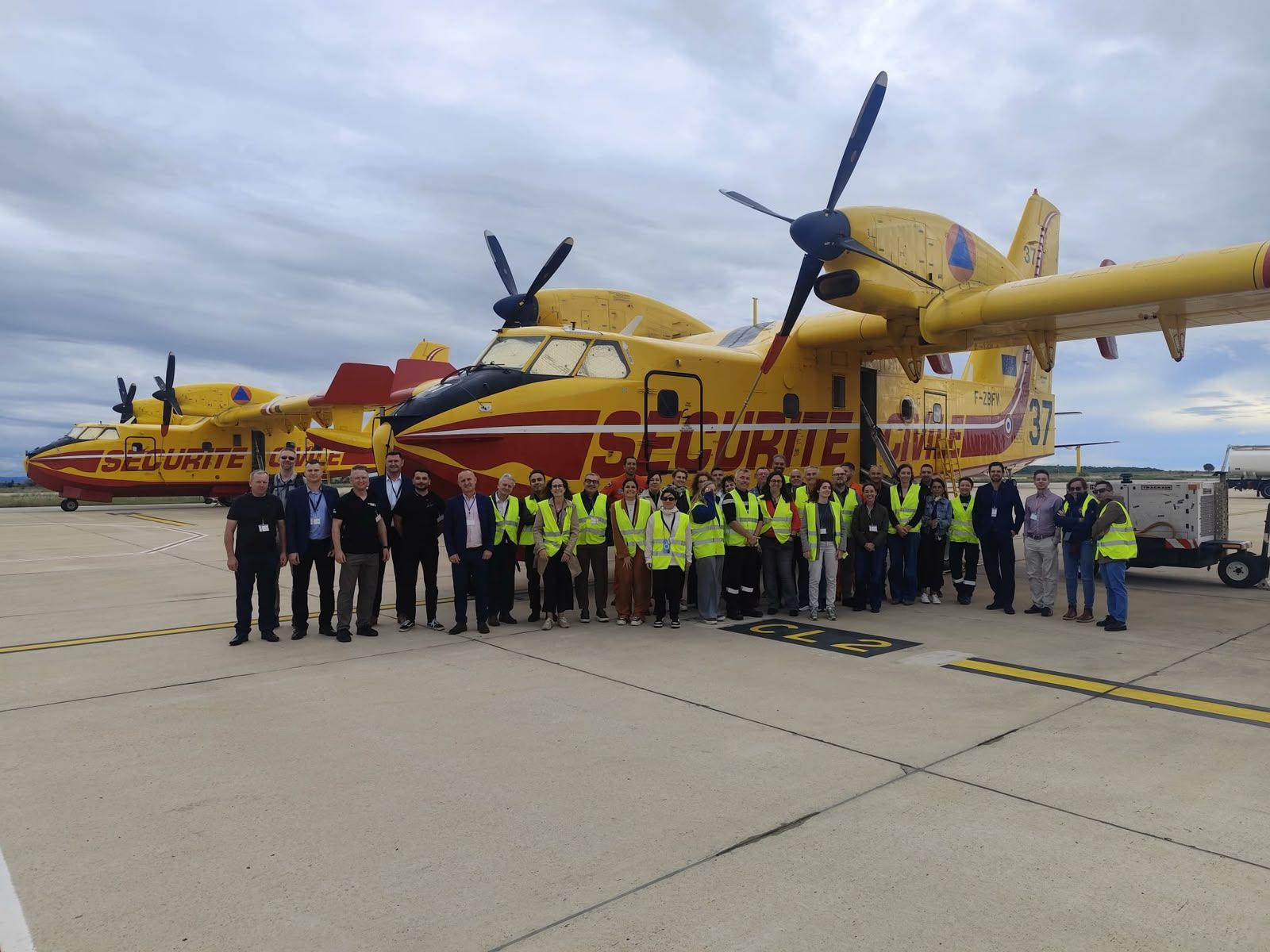 Group photo of the AWARENESS kick-off participants in front of a Sécurité Civile Canadair water bomber